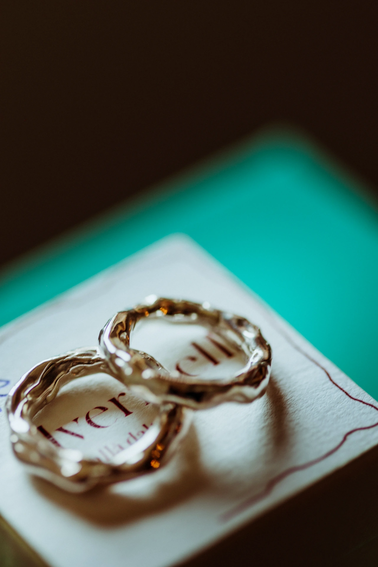 Wedding rings with organic gold texture on stationery at TMBTP