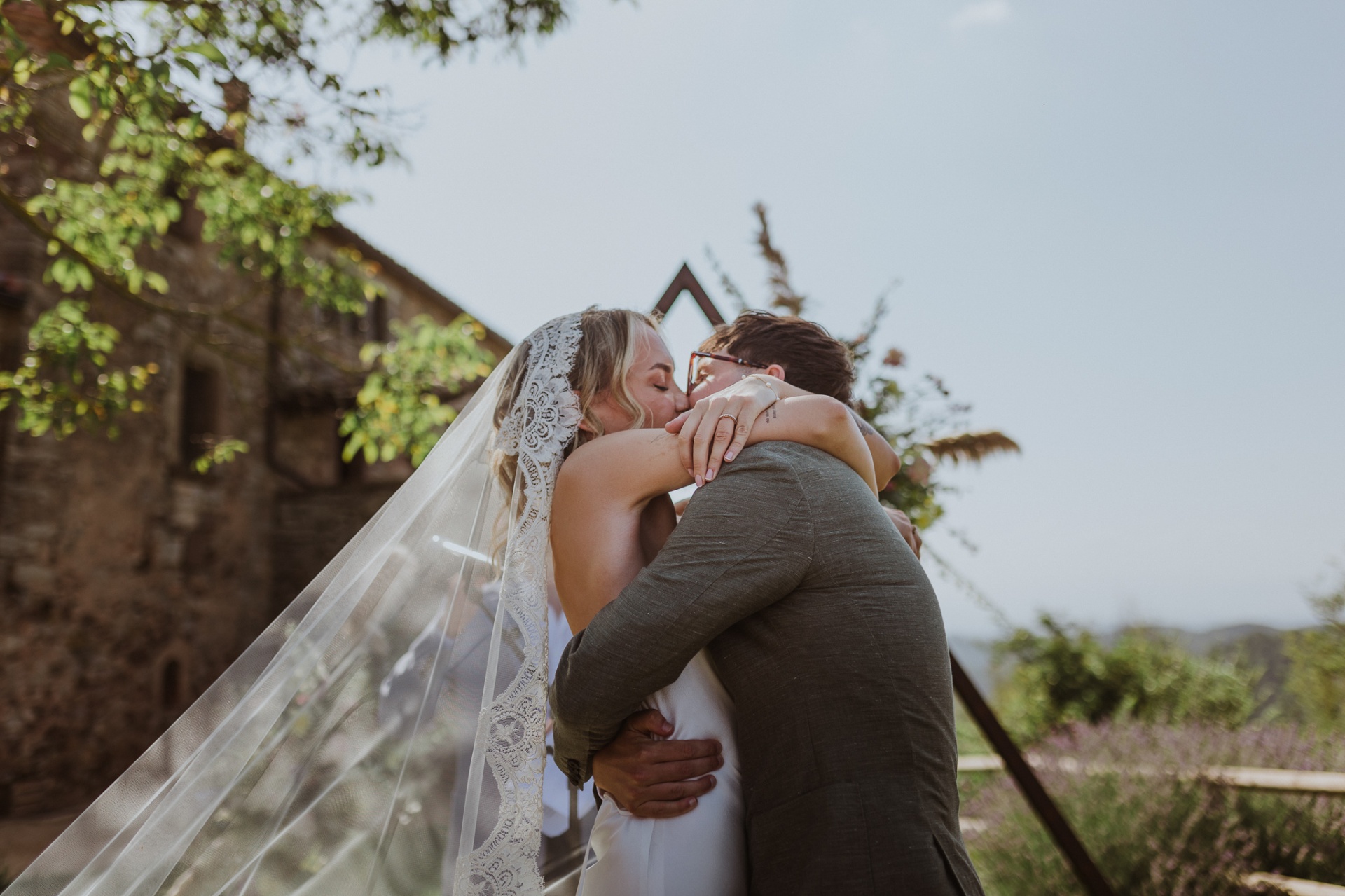 Ellie and Conor sharing their first kiss with lace veil flowing at TMBTP