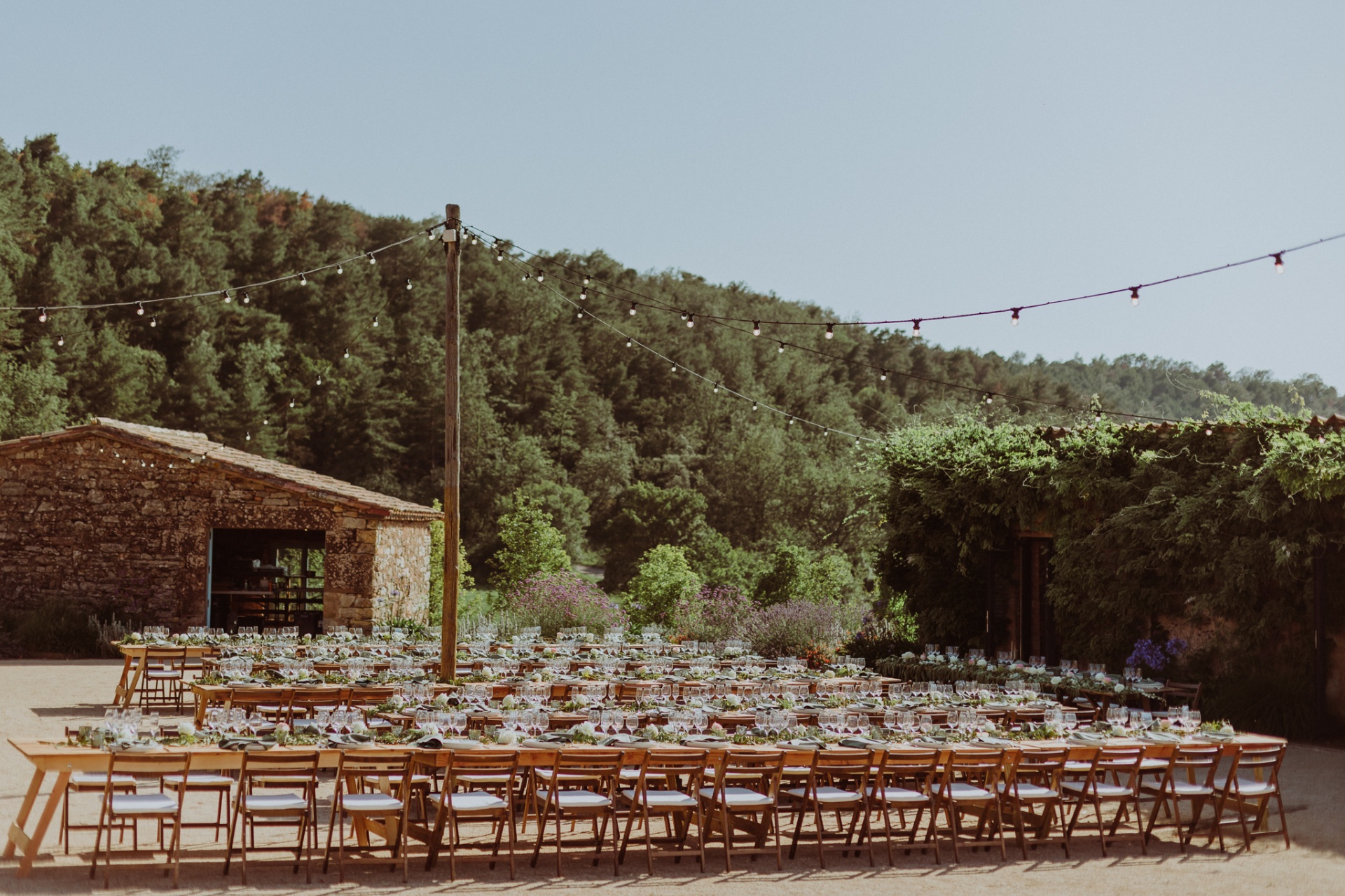 Outdoor reception table setting with string lights and forest views at TMBTP
