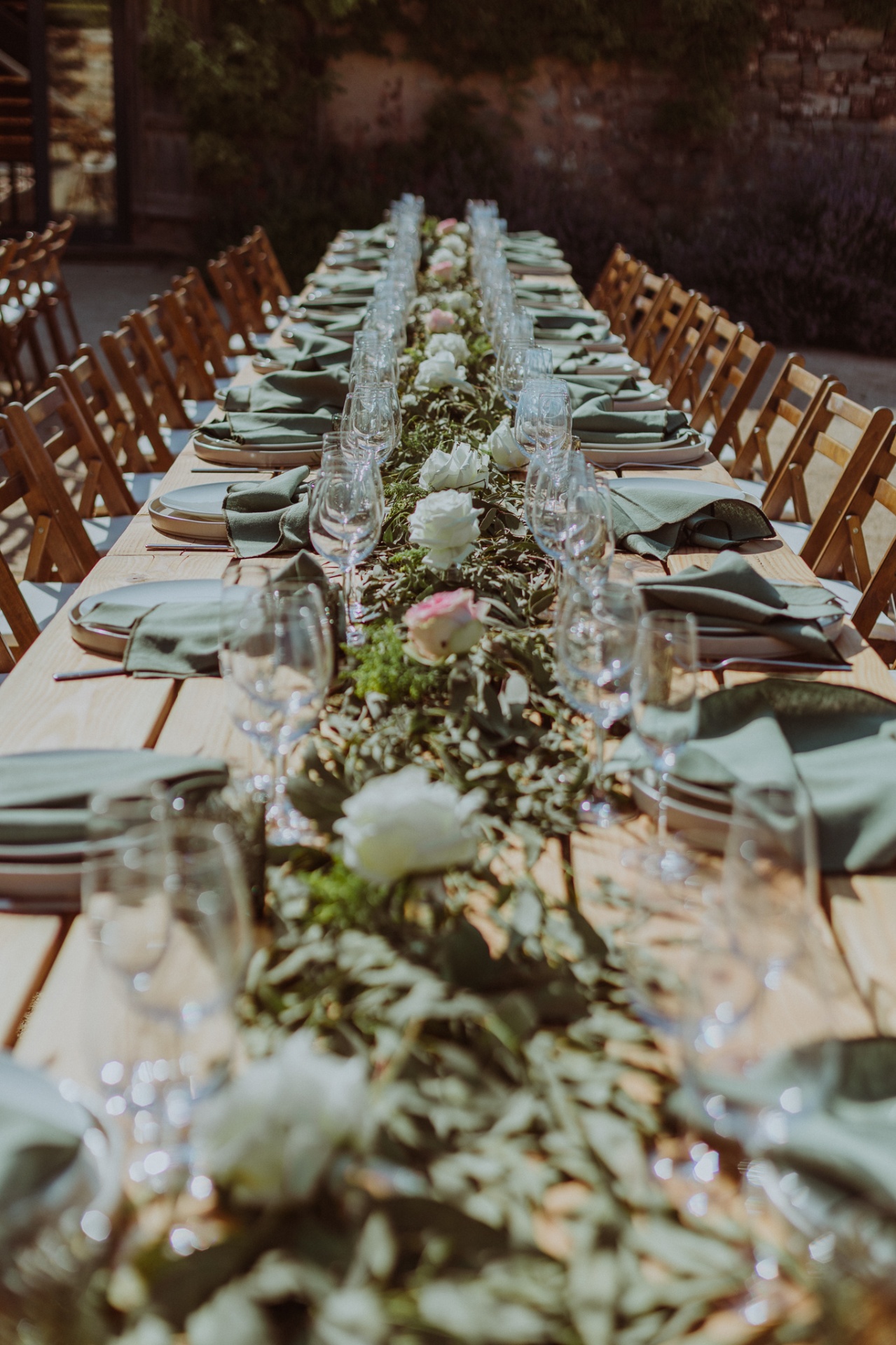 Table detail with eucalyptus garland, roses and sage green napkins
