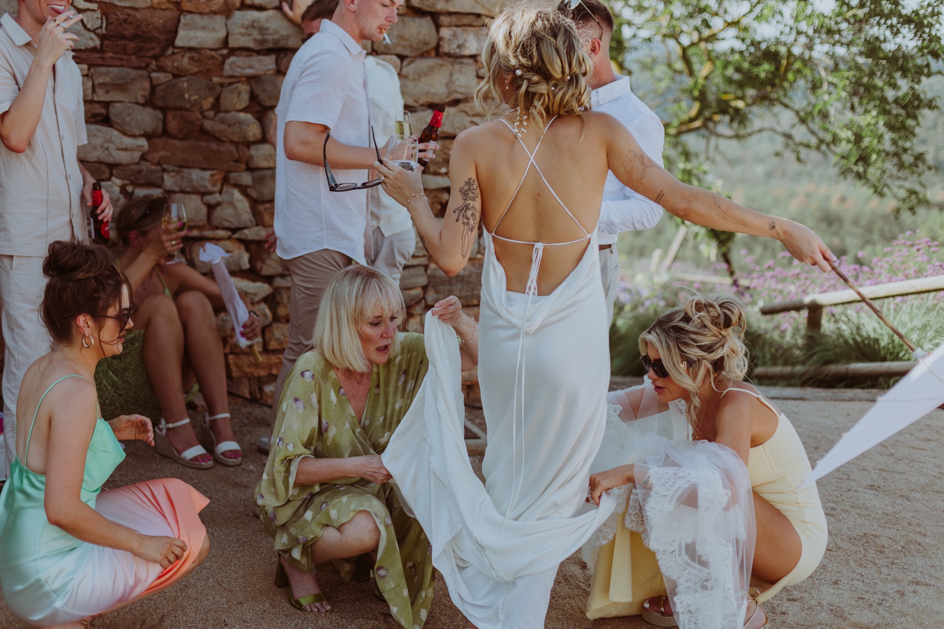 Guests admiring Ellie's open-back dress during cocktail hour at masía