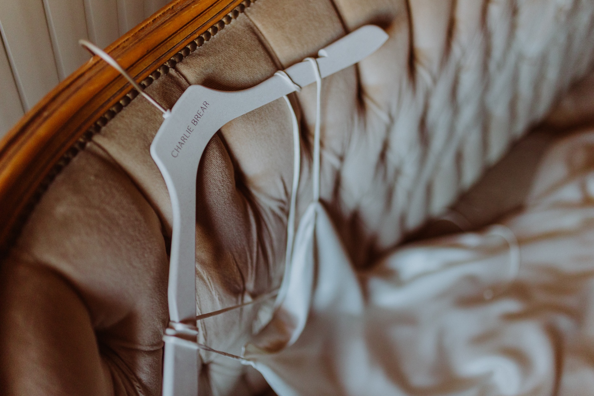 Charlie Brear wedding dress on hanger with warm golden light