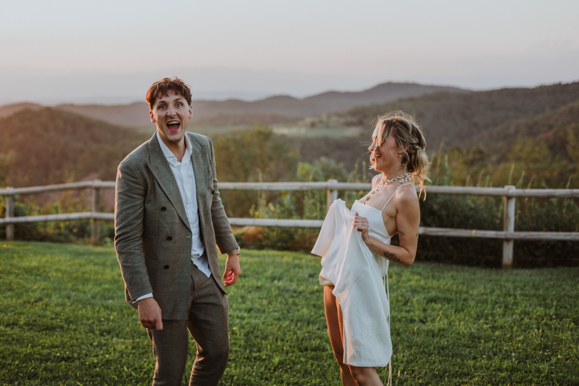 Ellie and Conor laughing on the lawn with Moianès mountains at dusk
