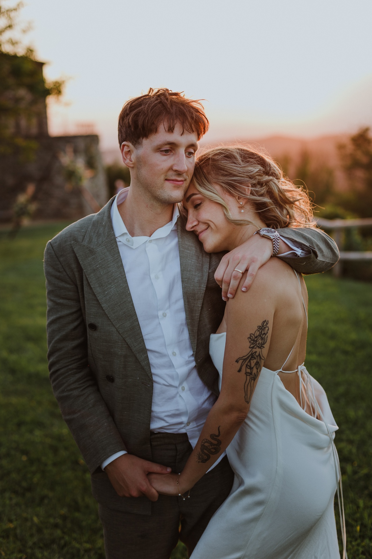 Intimate portrait of Ellie resting on Conor's shoulder at sunset
