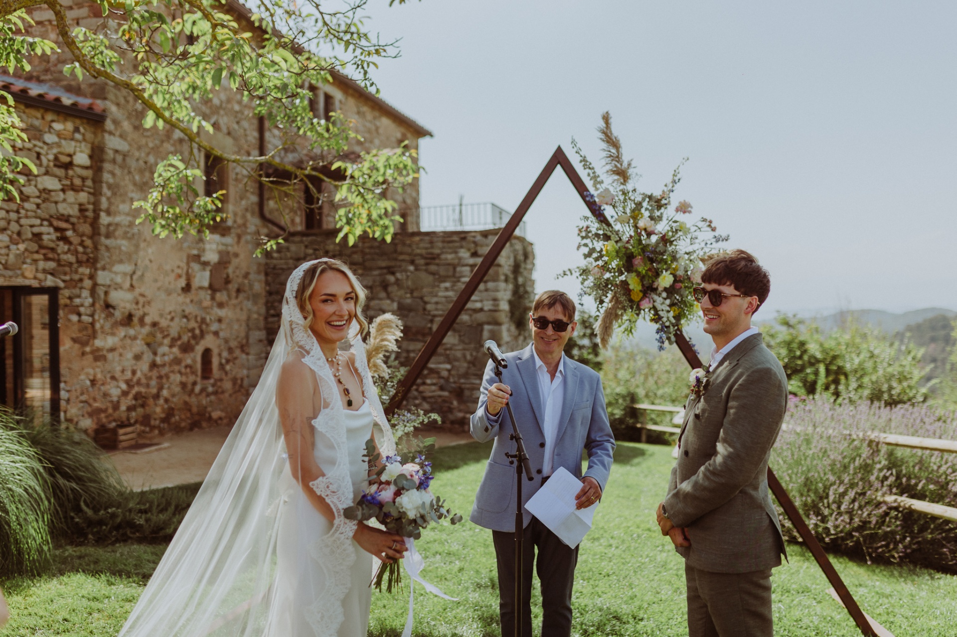 Ellie and Conor smiling at the altar with officiant at TMBTP ceremony