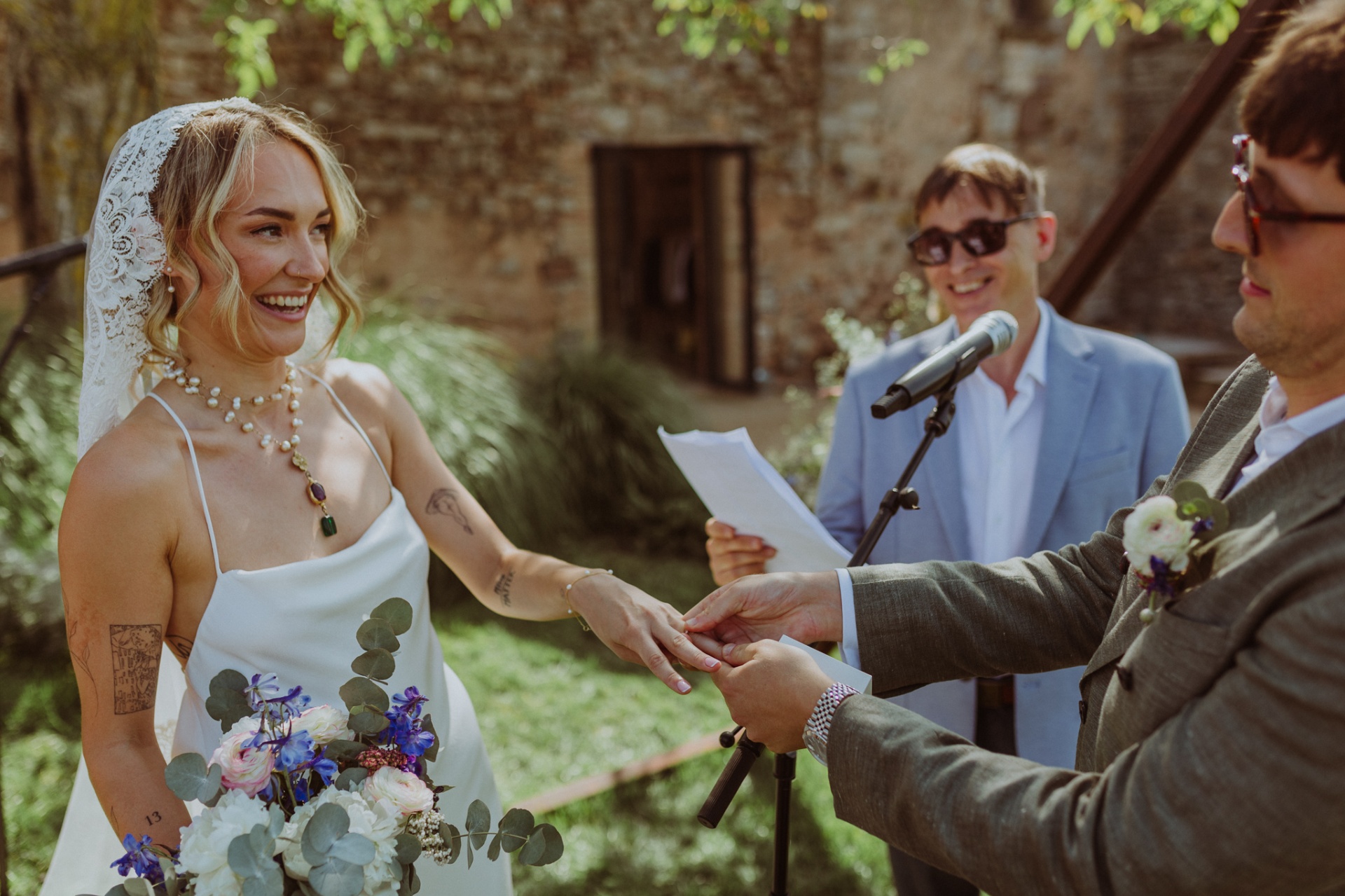 Ellie laughing while exchanging rings with Conor during ceremony