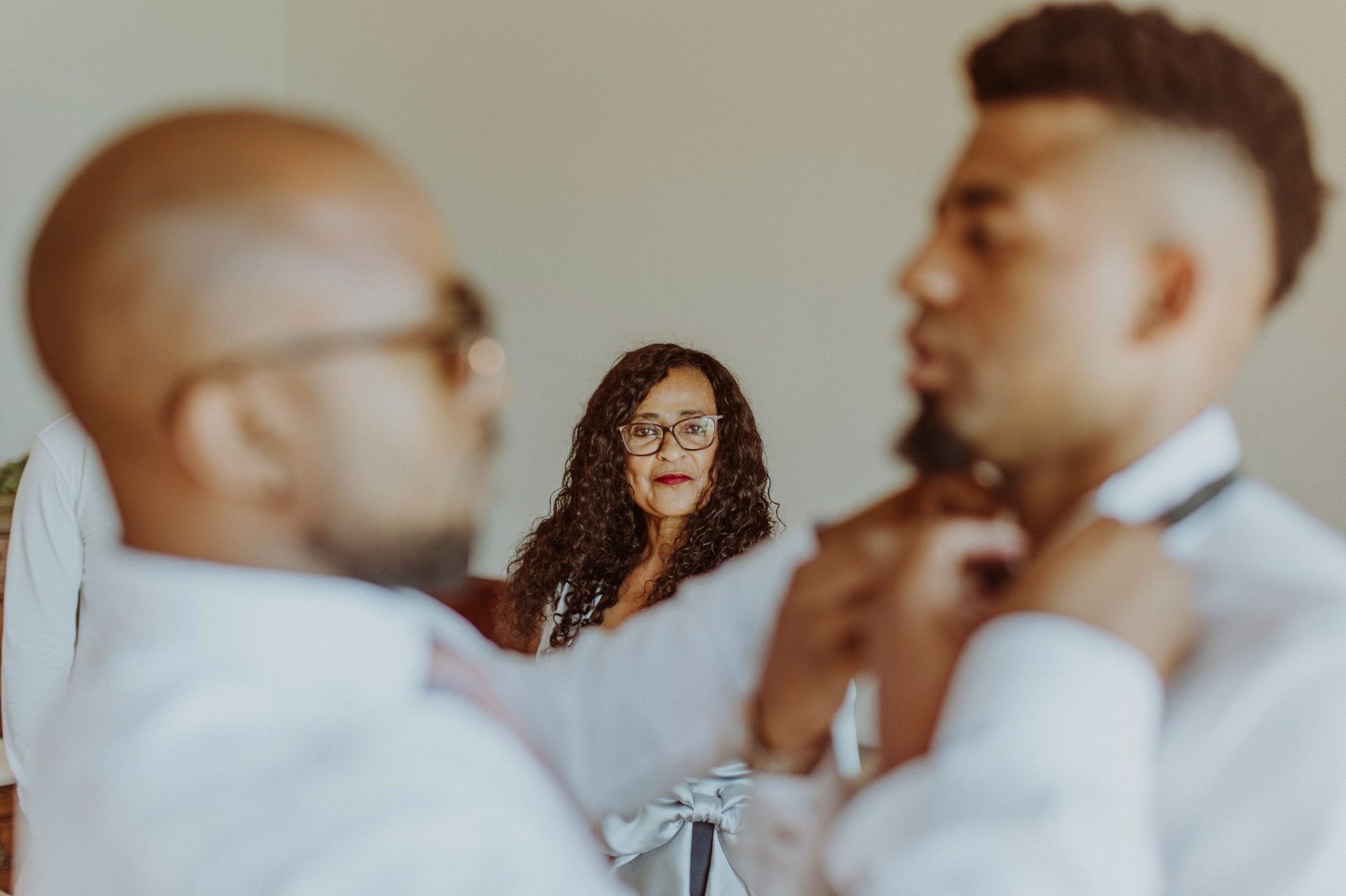 Mother watching her son get ready, adjusting bow tie at Castell de Tamarit