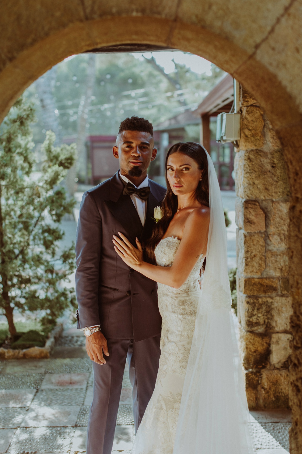 Laura and Jose posing under stone arch at Castell de Tamarit