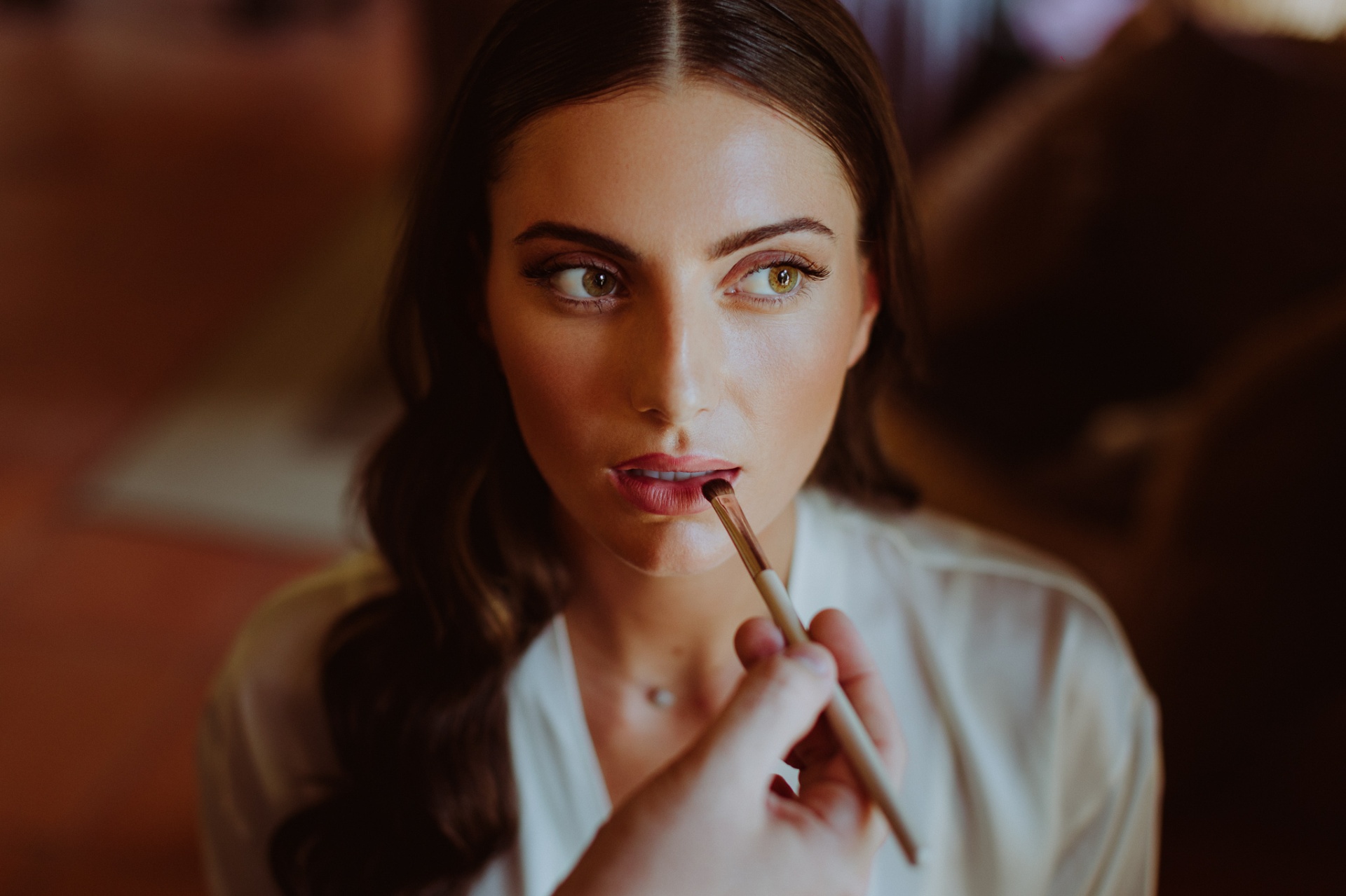 Laura getting makeup applied, close-up bridal beauty portrait