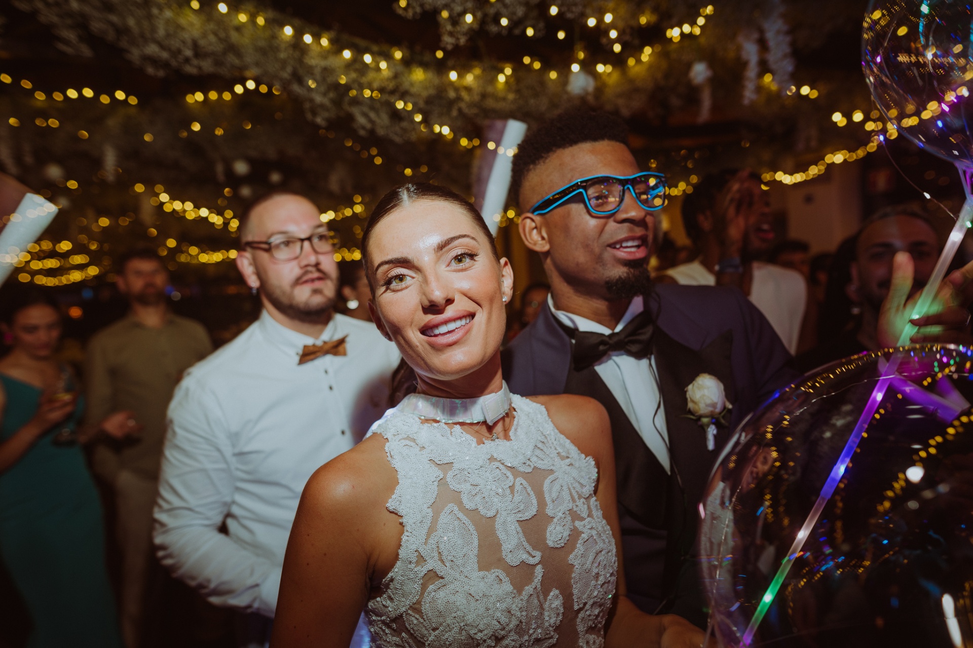 Laura smiling with Jose wearing neon glasses during hora loca party at Castell de Tamarit