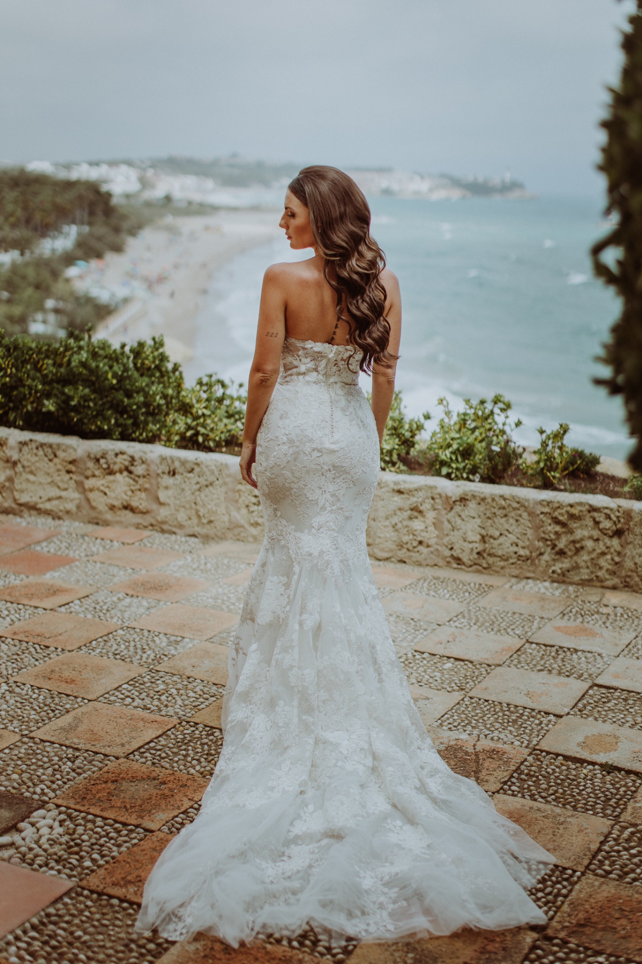 Laura in lace wedding dress overlooking Mediterranean coast at Castell de Tamarit