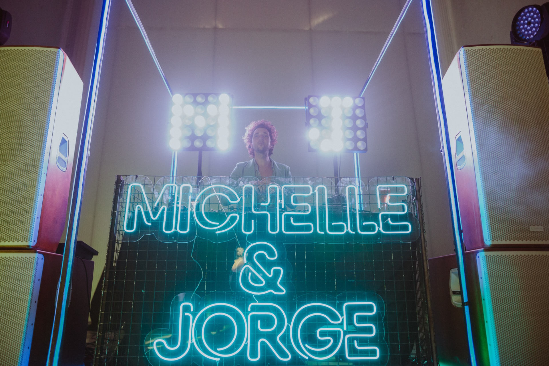 DJ con cartel de neón Michelle & Jorge durante la fiesta nocturna en la capilla de La Cartuja de Ara Christi