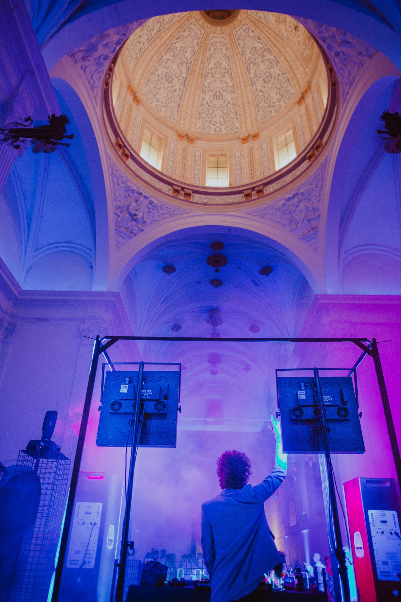 DJ pinchando bajo la cúpula barroca de la capilla de La Cartuja de Ara Christi con luces azules y violetas y humo
