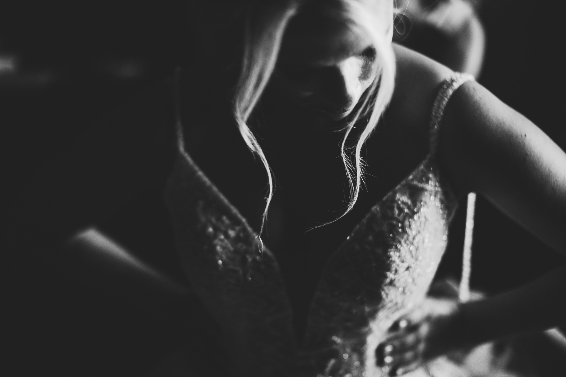 Detalle en blanco y negro del vestido de novia con pedrería y luz artística