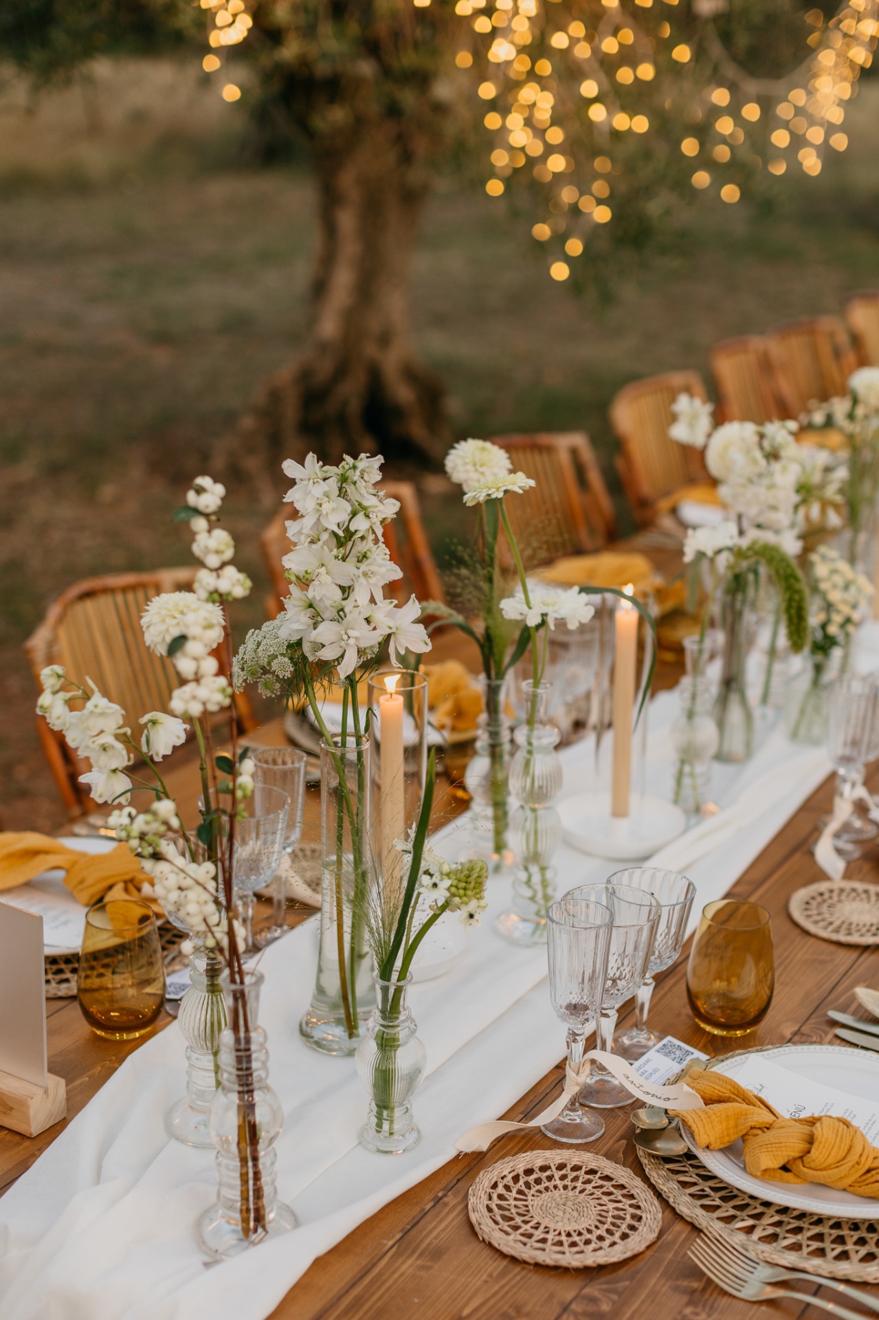 Table flowers and candles under fairy lights